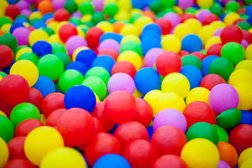 Fototapeta na wymiar Close-up of multi-colored bright round plastic balls in large numbers. Background for children's holiday. Children's birthday