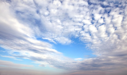Obraz premium Beautiful panoramic sky landscape with white flying clouds extending over the skyline line
