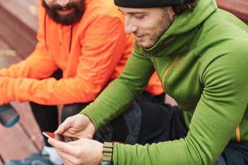 Two fit young sportsmen resting after work out outdoors