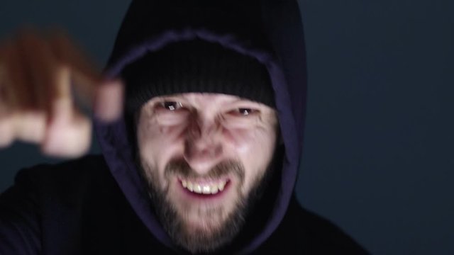 angry bearded man in hoody shout in anger and pointing finger at the camera