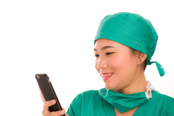 Asian Chinese woman as successful physician using hand phone - young beautiful and happy medicine doctor or chief hospital nurse smiling with internet mobile phone