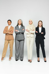 Obraz premium beautiful multicultural women standing with crossed arms on white