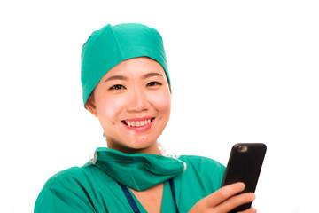 Asian Chinese woman as successful physician using hand phone - young beautiful and happy medicine doctor or chief hospital nurse smiling with internet mobile phone