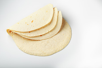 Tortilla on a white isolated background. Corn tortilla or simply tortilla is a type of thin unleavened bread made from Hominy.