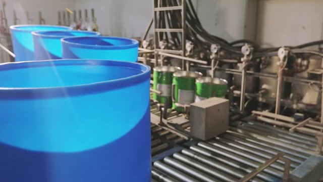 Blue barrels on an automated line in a factory. The process of colorization in the factory