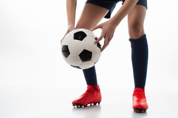 isolated female footballer on a white background holding the ball