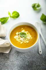 Homemade carrot pumpkin soup with cheese and basil