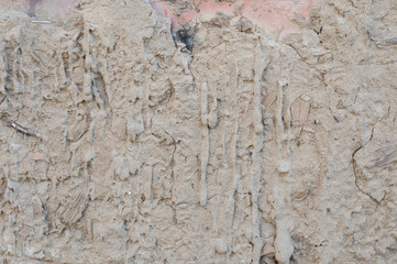 Old cracked clay plaster on brick wall
