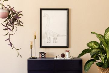 Stylish interior of living room with black mock up poster frame, plants, table lamp, blue navy...