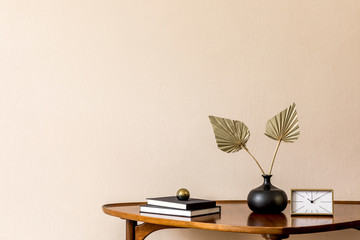 Stylish composition on the design wooden table with gold clock, books and paper flowers in vase....