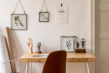 Design scandinavian interior of home office space with a lot of mock up photo frames, wooden desk,...