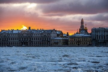 Fototapeta premium colorful dawn over the Palace embankment across the Neva river, covered with sharp ice floes