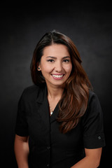 Smiling woman in black spa uniform 