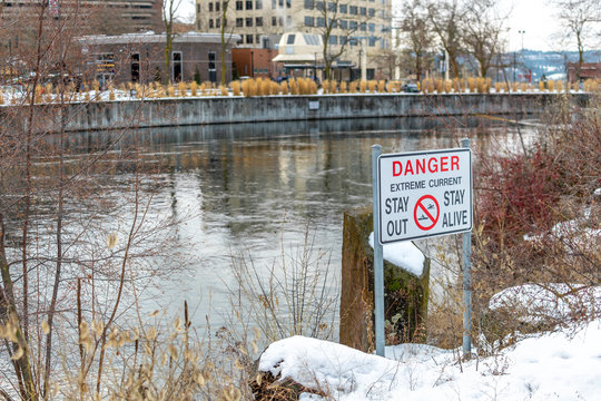A warning danger sign at the edge of the Spokane River in Washington state, USA, warning of extreme current.