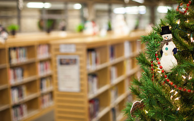 Close-up of Christmas tree with ornament at book shop. Christmas eve in library. Christmas sale, New Year holiday, celebration