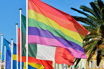 Rainbow flag on the background of national flags of different countries in Nice