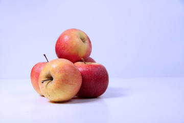 a pile of red apples isolated on light background