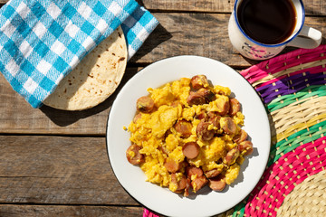 Scrambled eggs with sausage breakfast on wooden background