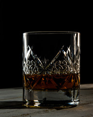 Bottle and glass of whiskey jn the dark background