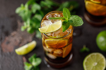 Cuba Libre with brown rum, cola, mint and lime. Cuba Libre or long island iced tea cocktail with strong drinks - obrazy, fototapety, plakaty