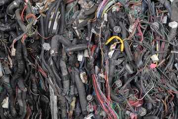 Stack of car wire, plastic cover, plastic connector and copper for recycling. Scrap car parts for recycling.