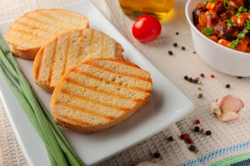 Grilled baked bread with green onions on a white plate
