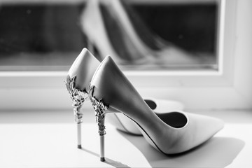 Black and white photo. Pair of wedding shoes. White shoes of the bride close-up. 