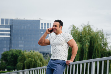 Sports guy stands and talks on the phone. Lifestyle