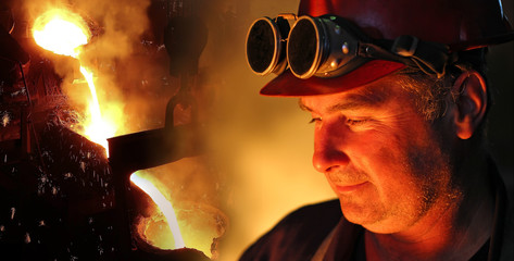 Liquid metal in the foundry, melting iron in furnace, steel mill. Worker with goggles and helmet...