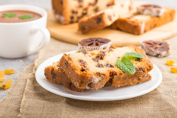 Homemade cake with raisins, dried persimmon and a cup of hot chocolate on a gray concrete background. side view, selective focus.