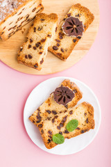 Homemade cake with raisins and dried persimmon on a pink pastel background. Top view, copy space.