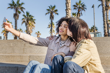 couple of young women doing a selfie with a phone