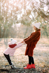 Mother and daughter have fun in the pine forest.