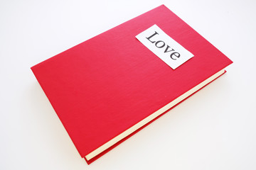 on the red book is a sheet of paper on which is written love