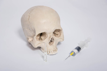 Skull, syringe and ampoule close-up on a white background.