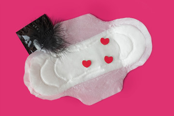 women intimate hygiene products - sanitary pads and tampon on pink background. Sex during menstruation, condom, tampon, pad. protection during sex. ovulation and gynecology. Intimate life