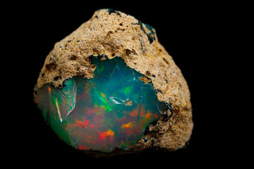 macro mineral stone rare and beautiful opals on a black background