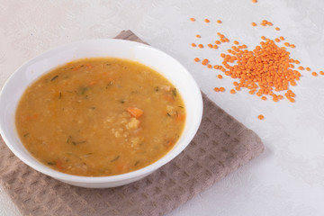 Lentil cream soup over brown towel, top view food