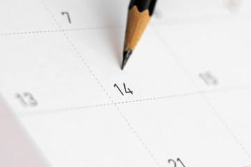 pencil point at date of february 14 on the calendar. - Valentine's Day concept.