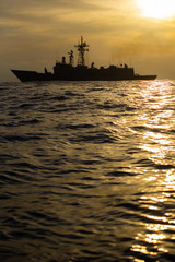 A military nato us navy boat frigate sailing in the ocean with antennas and missiles
