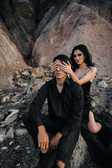 Asian couple in love hugs sitting on the rocks. Love story