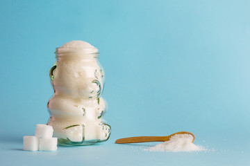 The problem of sugar in baby food and drinks. Glass jar of baby food baby with sugar and a spoon...