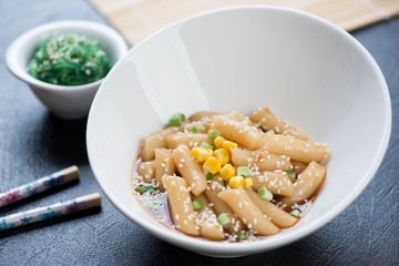White bowl with korean traditional snack tteok-bokki, selective focus, horizontal shot