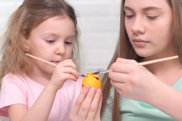 Happy easter. Two sisters painting Easter eggs. Happy family children preparing for Easter. Cute little child girl wearing bunny ears on Easter day.