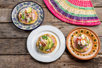 Mexican ham toast also called tostadas with beans and cheese on wooden background