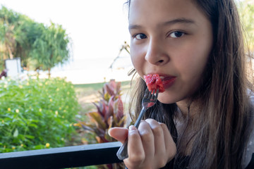 Tween girl eats watermelon with a fork
