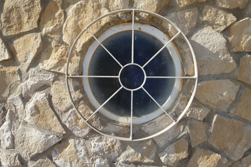 Round window with a circular metal grill