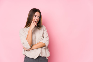 Young caucasian woman posing isolated relaxed thinking about something looking at a copy space.