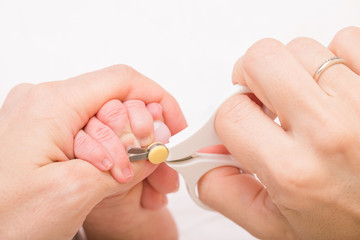 Mother cuts newborn baby fingernails