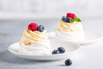 Delicious Pavlova cake with whipped cream and fresh raspberry and blueberry. Selective focus